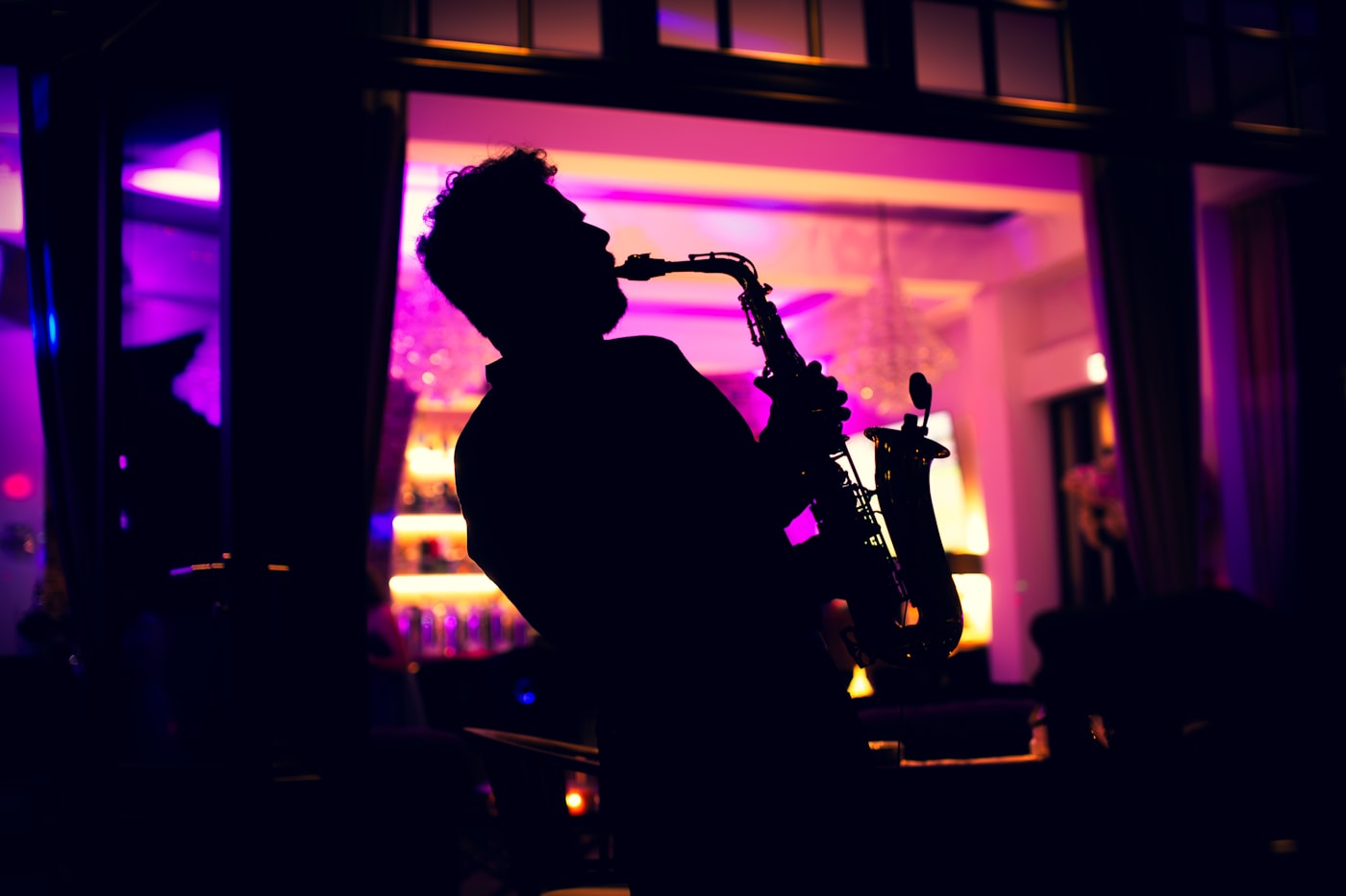 Saxophonist performing in low stage light